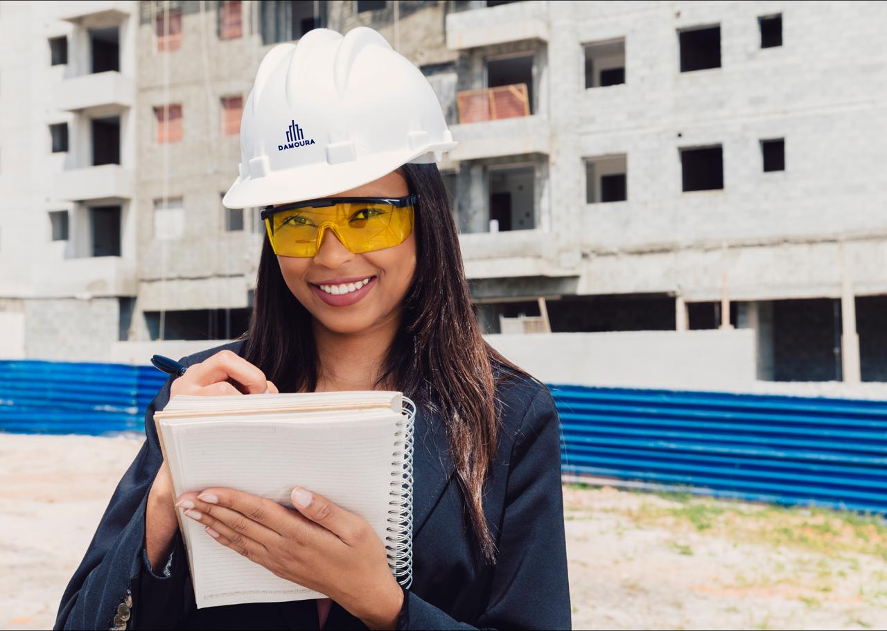 Engenheira da DAMOURA em obra, com capacete da empresa