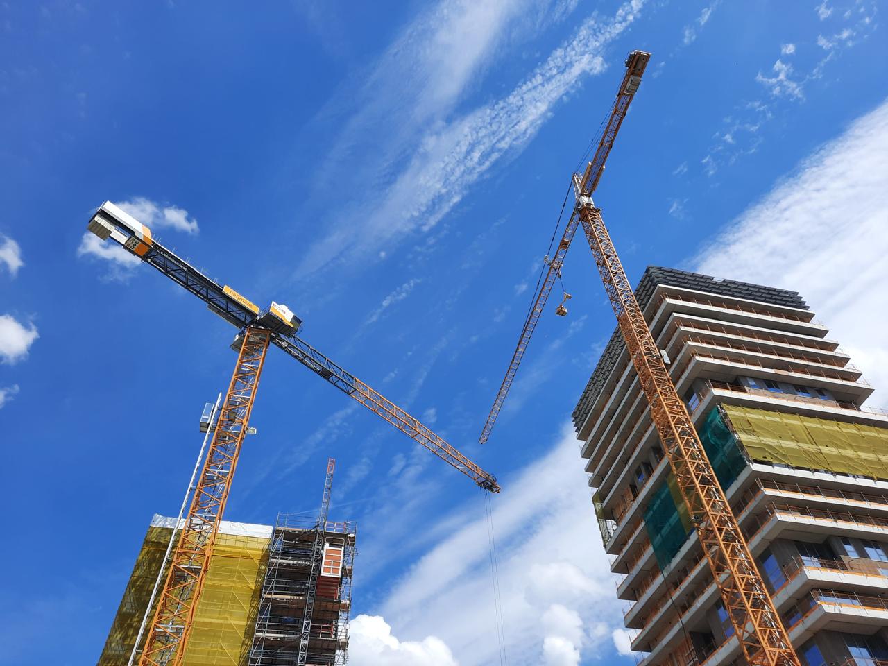 Edifício em construção com gruas torre